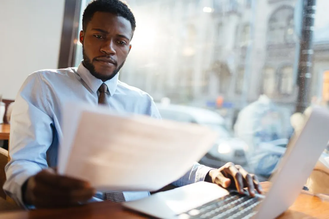 Businessman Reading Report At Desk